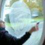 Mr.t Fönsterputsare tvätta ett fönster med vit frostad glas i en villa i Göteborg.
