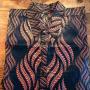 A shirt with long sleeves in black background and wavelike purple pattern.