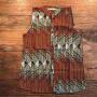 Armless blouse in pattern that is mainly red and grey